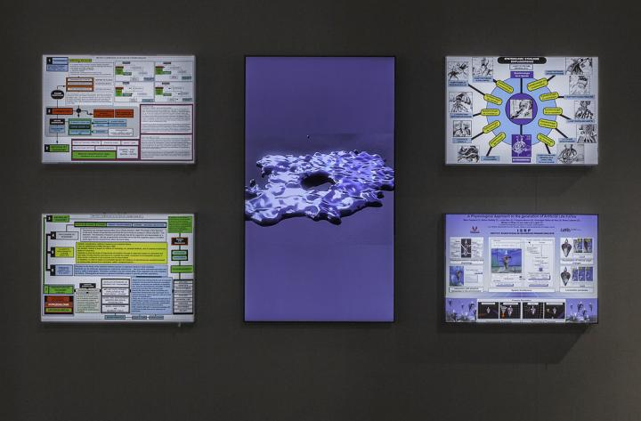 You can see four smaller screens and in the middle a larger screen in portrait format. On the four screens are various information graphics. The screen in the middle shows a blue entity.