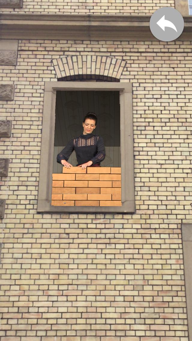A woman stands at the window and walling herself in