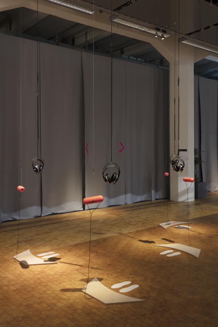 Headphones and large red plastic capsules hanging from the ceiling.