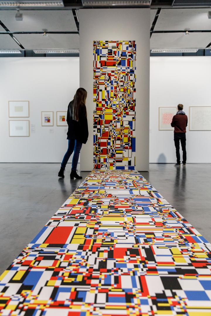 A mosaic of colored surfaces extends from the wall to the floor