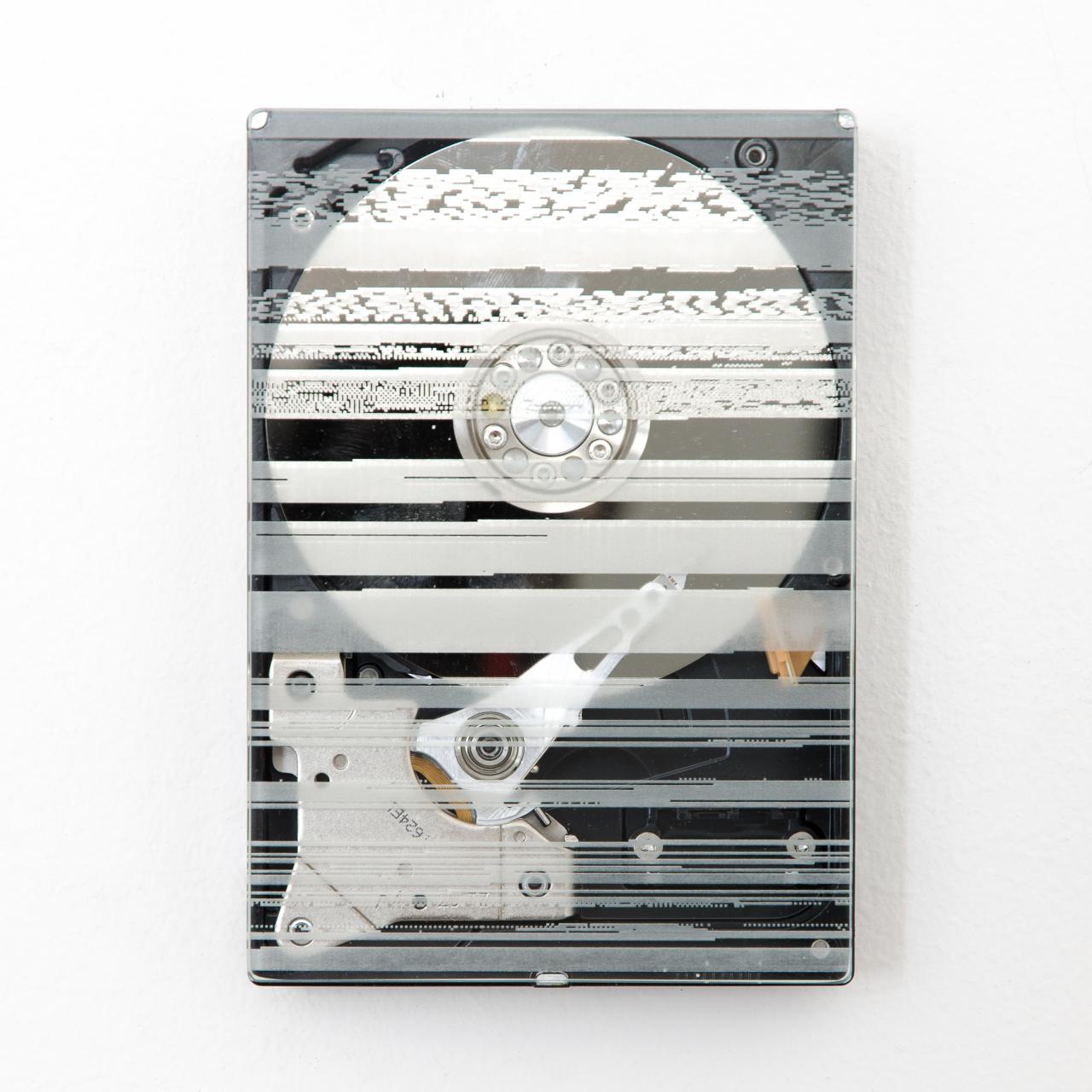Wall installation of a transparent hard disk with engravings