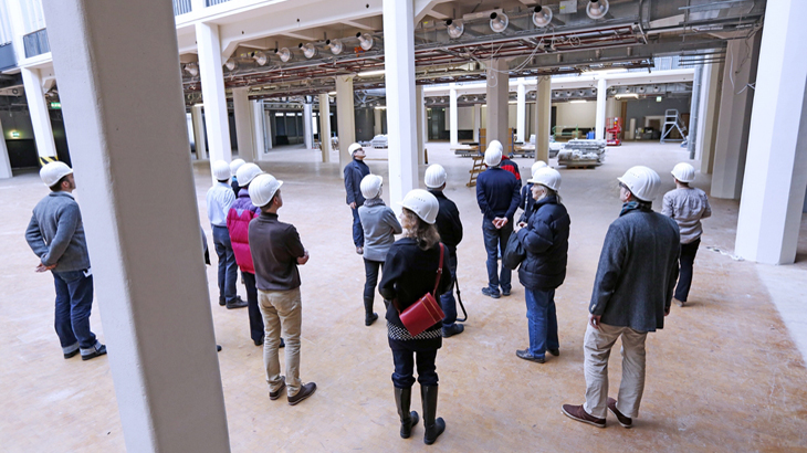 People with building-site helmets in atrium