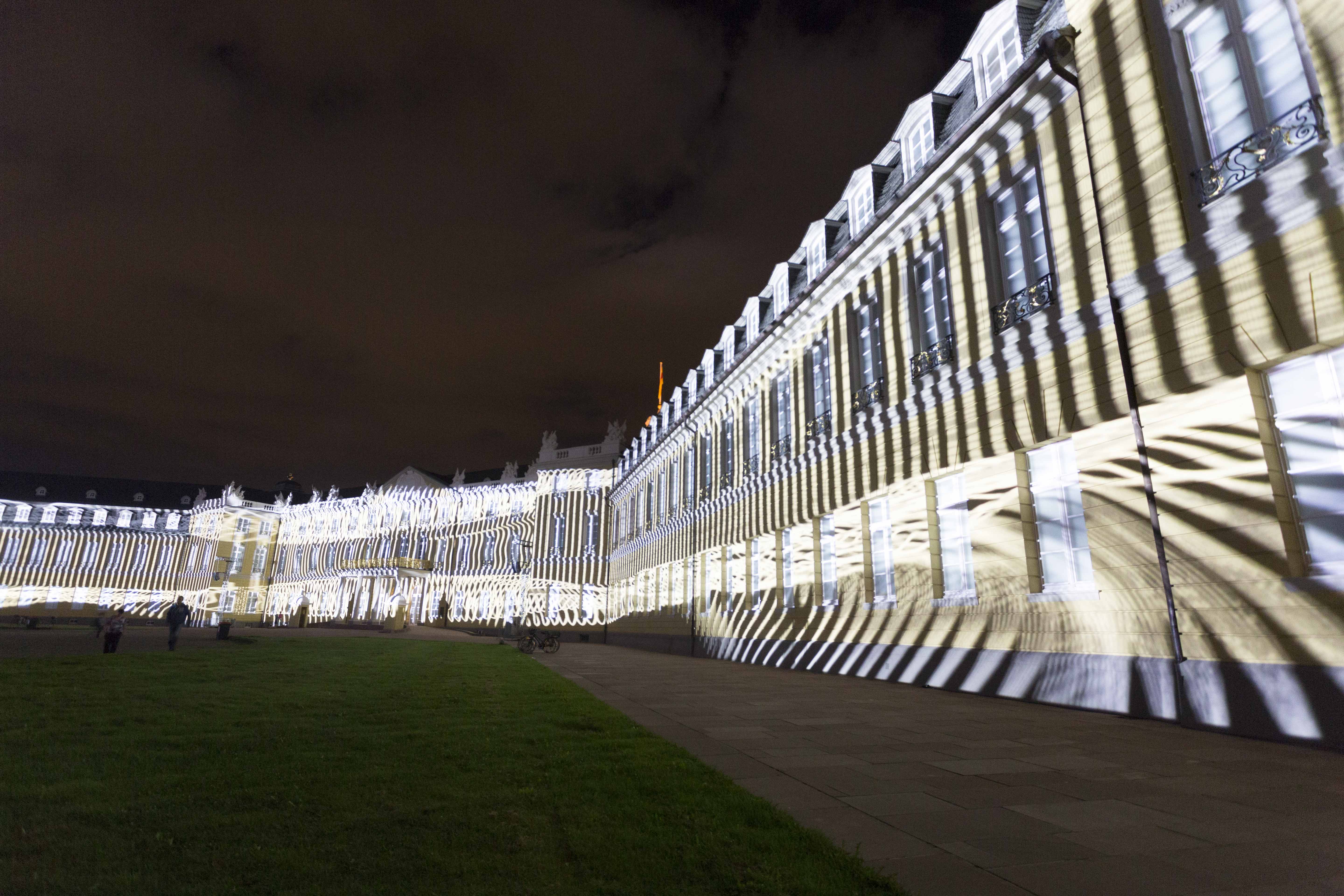 Diagonale, leuchtende Striche auf der Schlossfassade