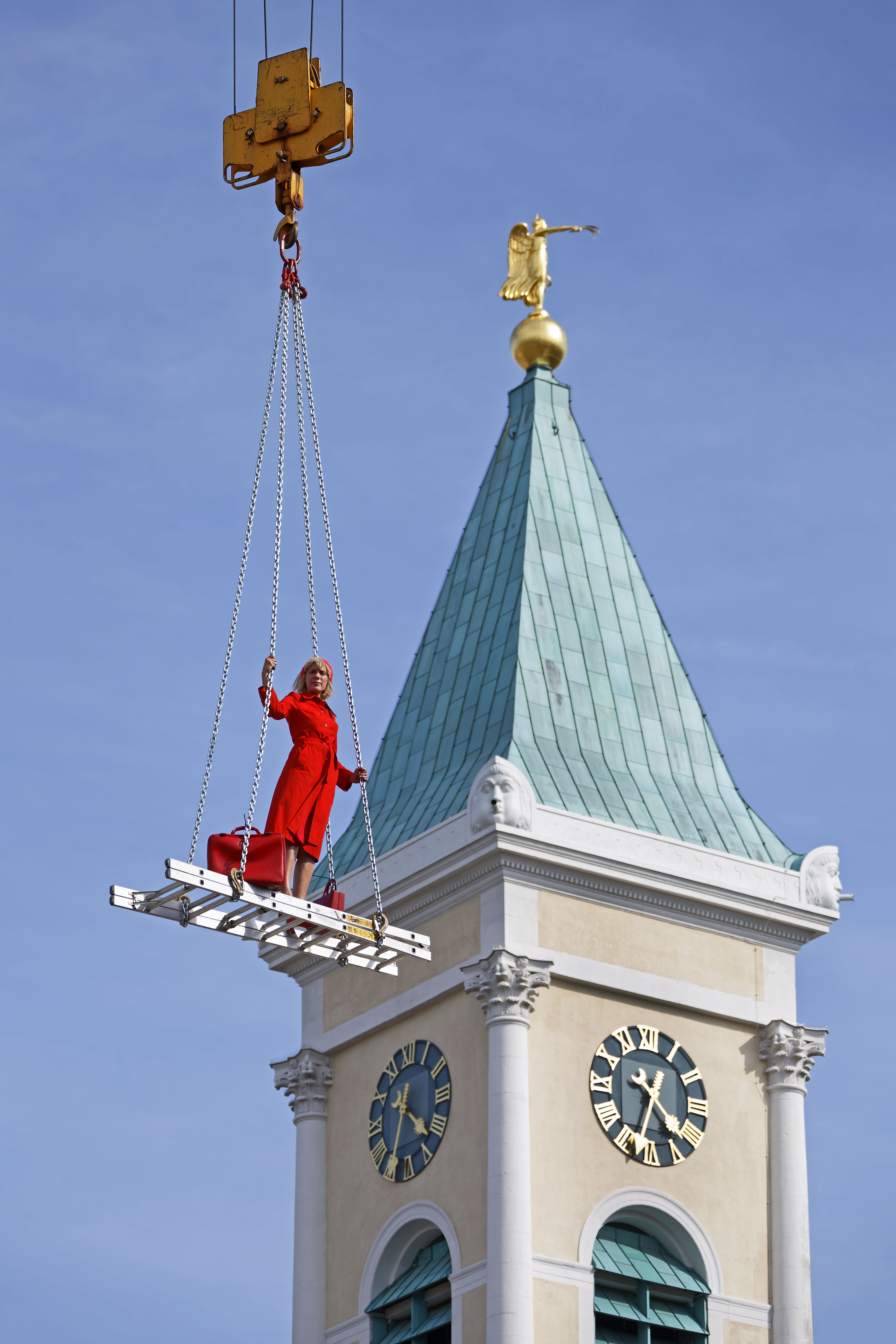 A blonde woman in a red dress on a floating staircase