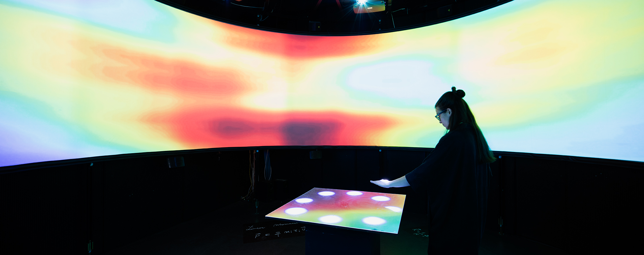 A woman interacting with a colorful panel
