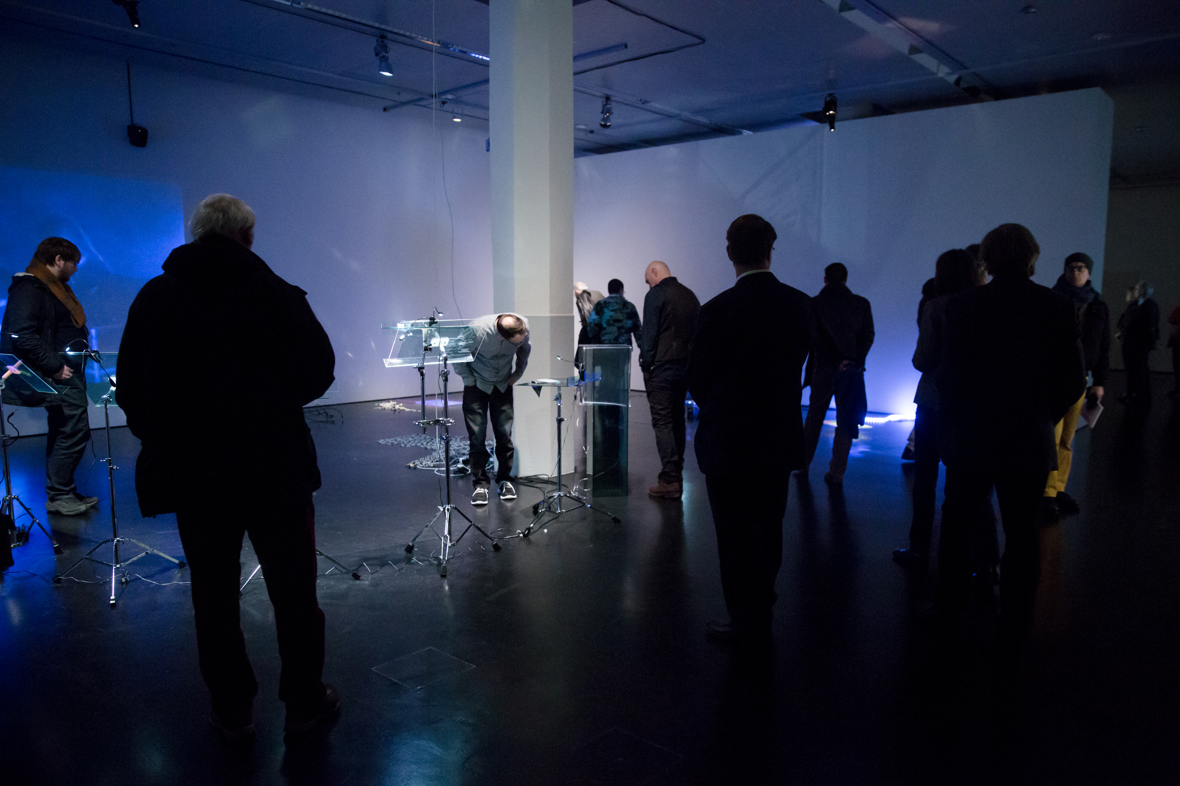 People stand in a blue room with different gadgets