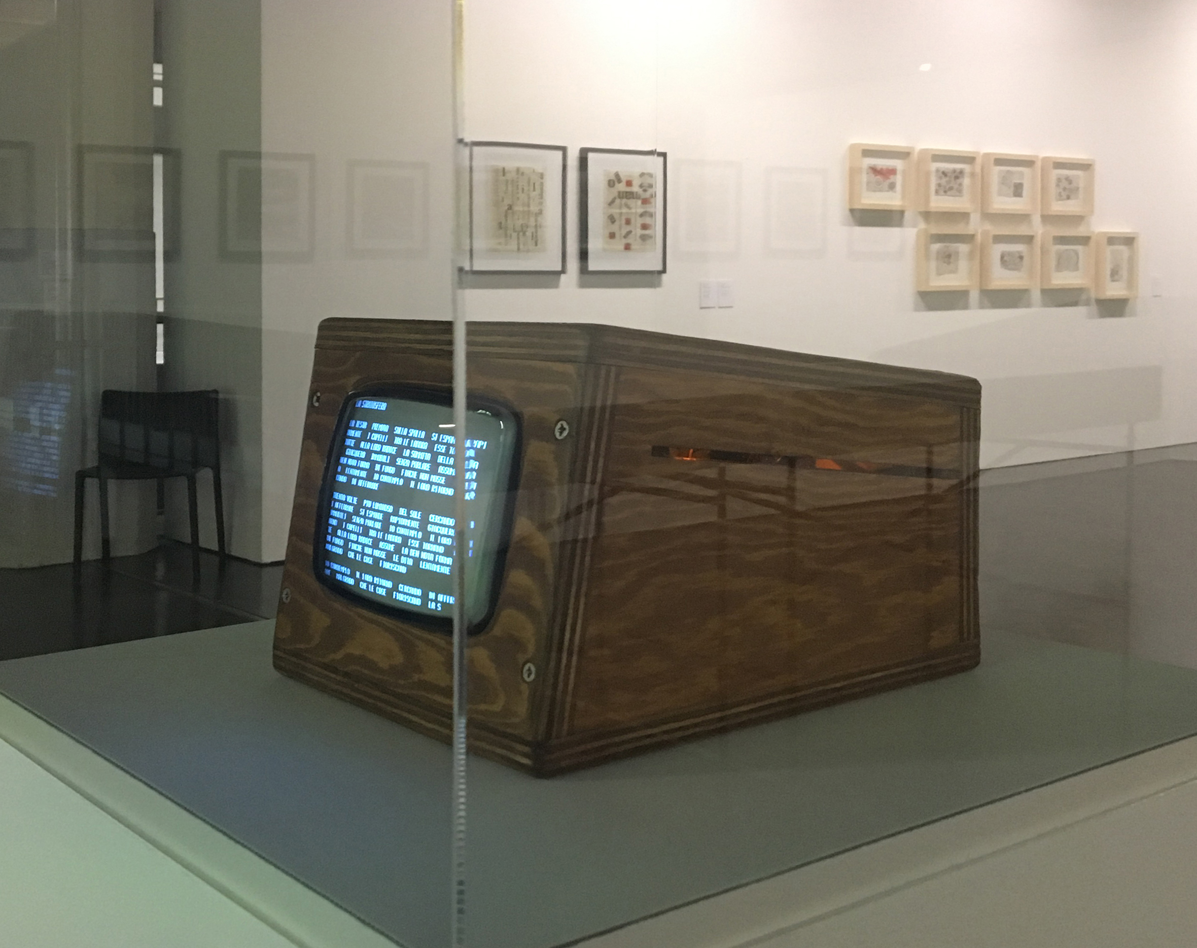 Photo of the reconstruction of the poem "Tape Mark I" by Nanni Balestrini: a small wooden box with a screen