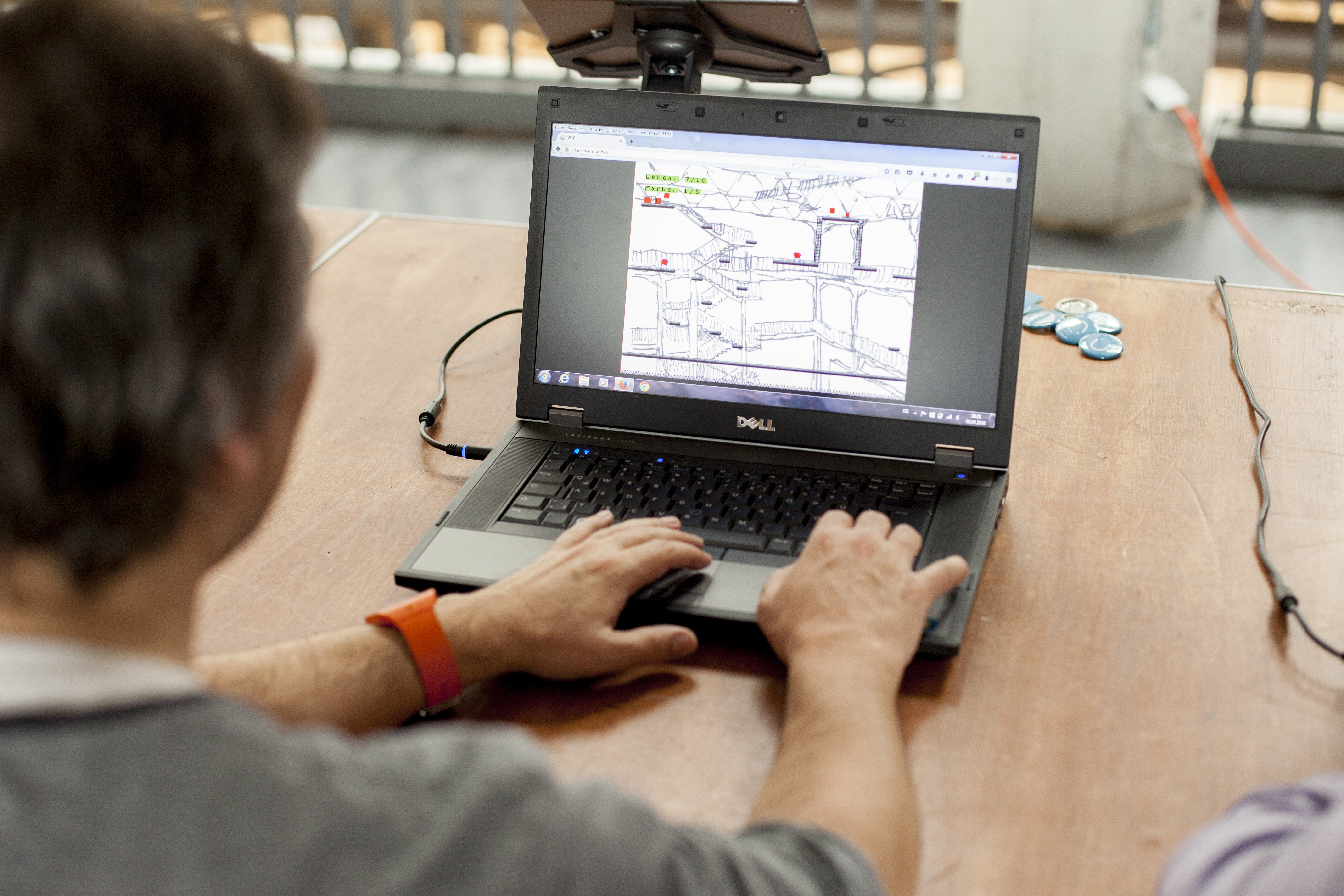Der Blick geht über die Schulter einer Person, die vor einem Laptop sitzt