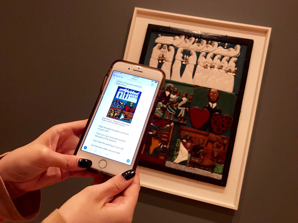 A mobile phone is held in front of a artwork, which then displays more detailed information about the artwork by means of text.