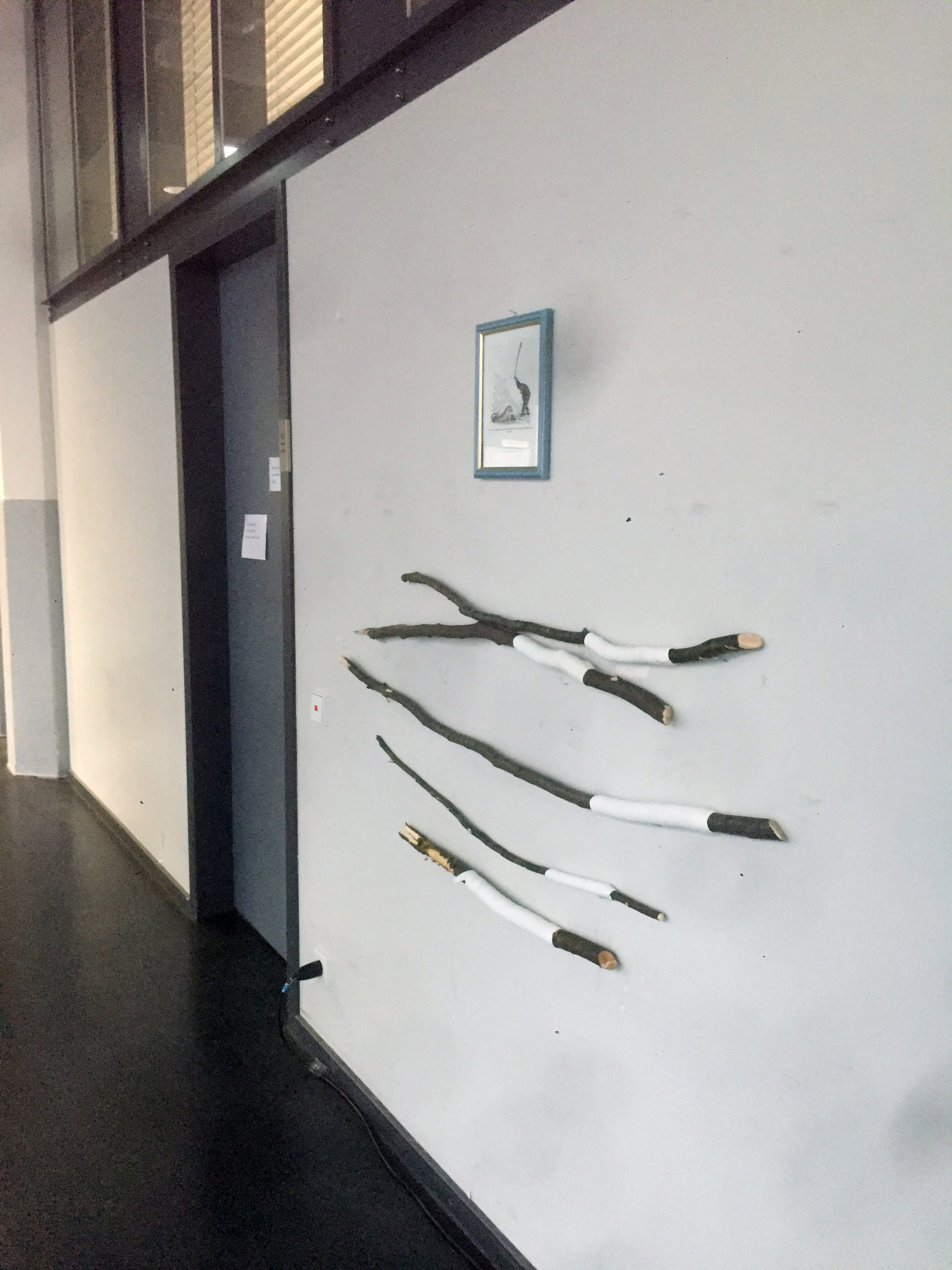 Die Schlagstöcke hängen an der Wand, unter einer alten sowjetischen Illustration "Savannenschimpanse schlägt wütend ein Stofftier mit einem Stock".