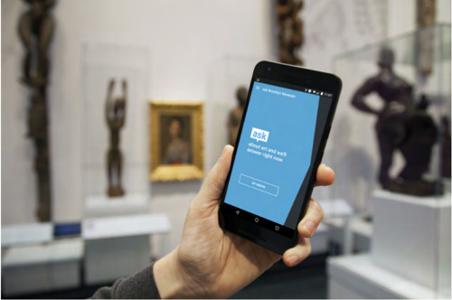 Mobile phone in the hand of a museum visitor. The museum bot ASK is started on the screen.