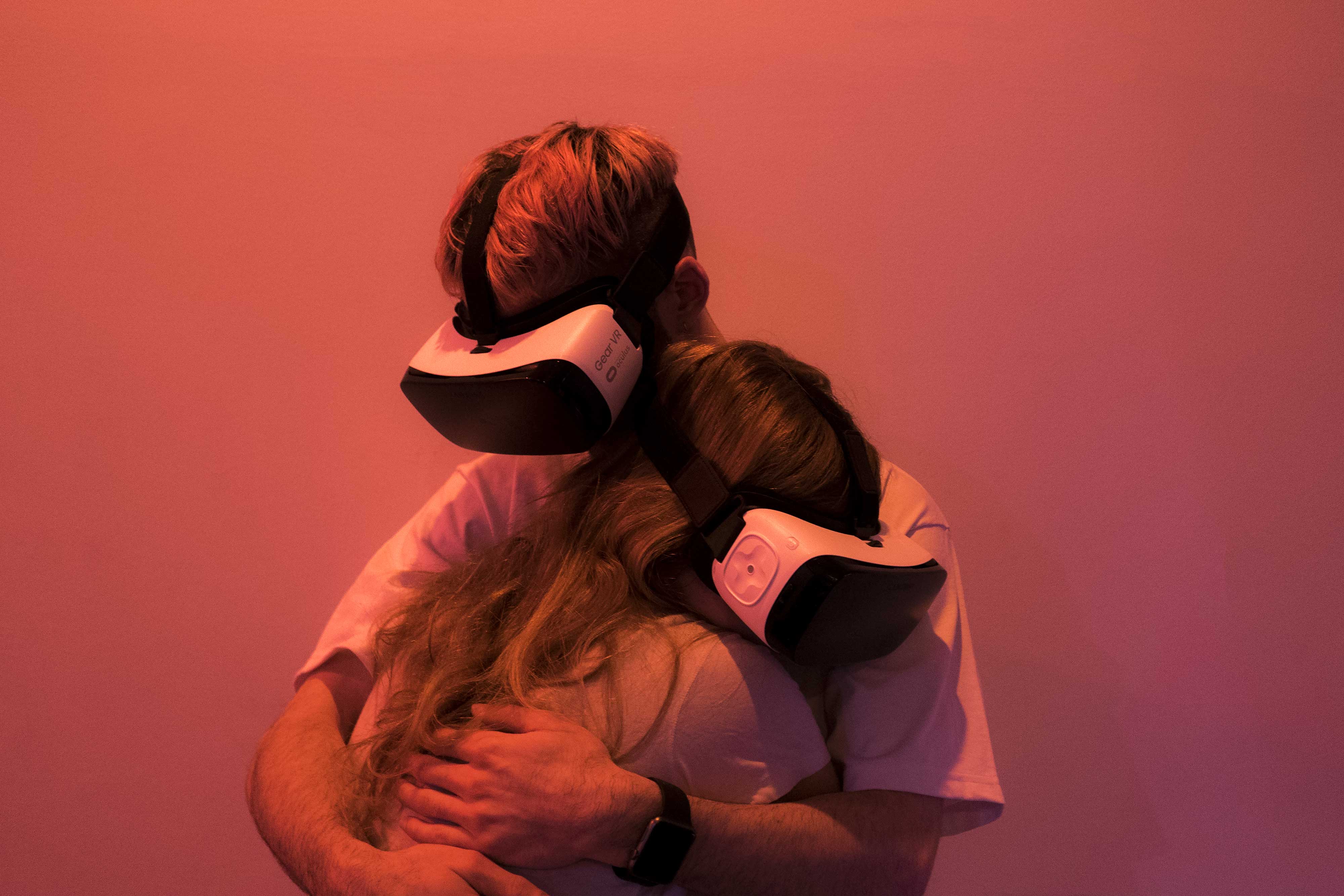 Two people with VR glasses hug each other 