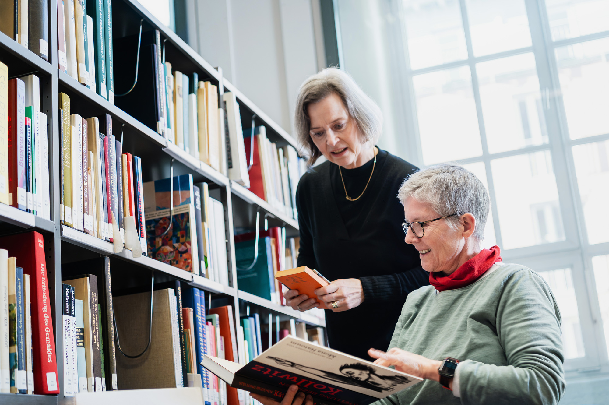 Zwei Frauen beim Einsortieren von Büchern.
