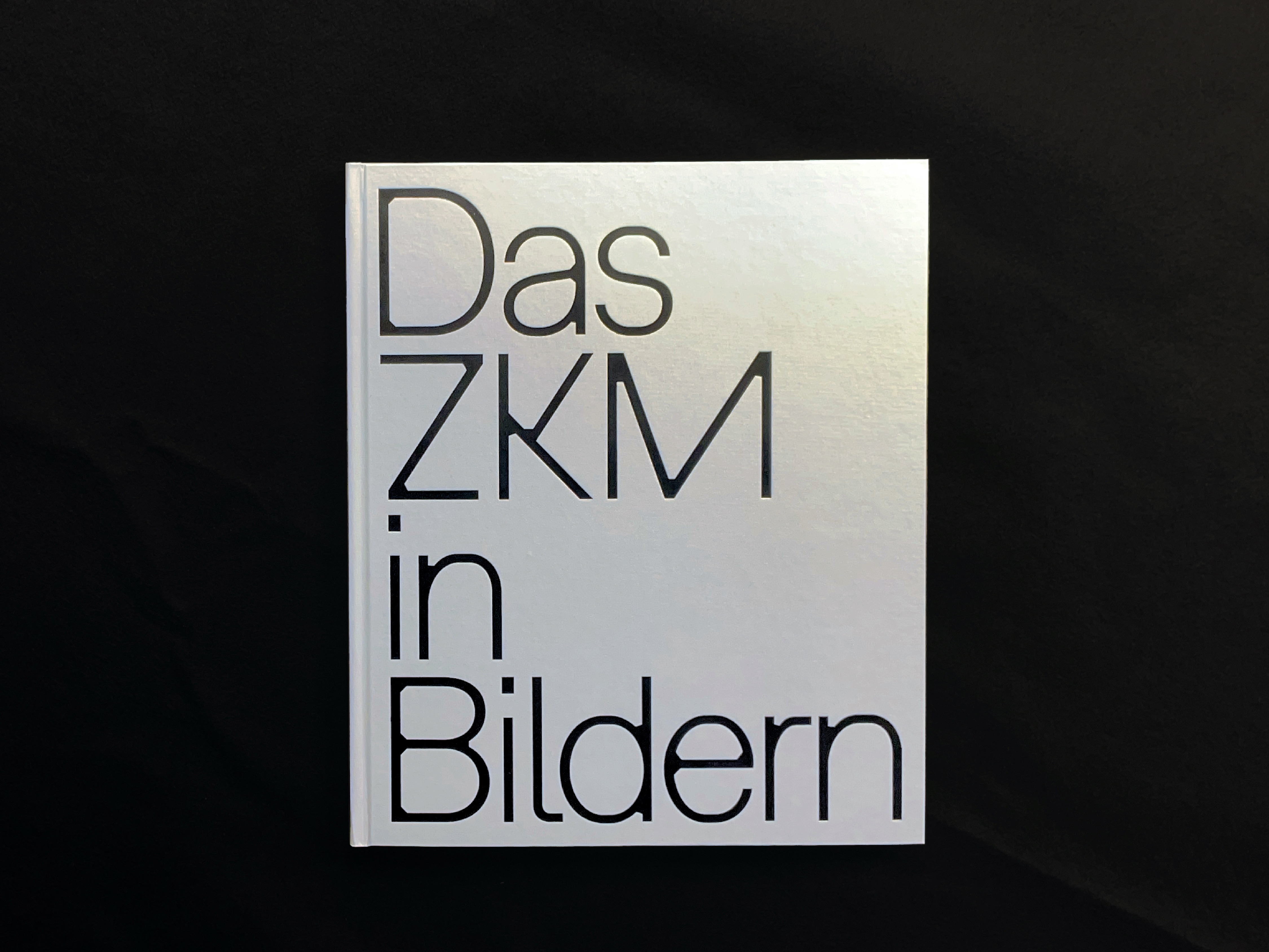 Cover von "Das ZKM in Bildern", schwarzer Schriftzug auf silbernem Grund