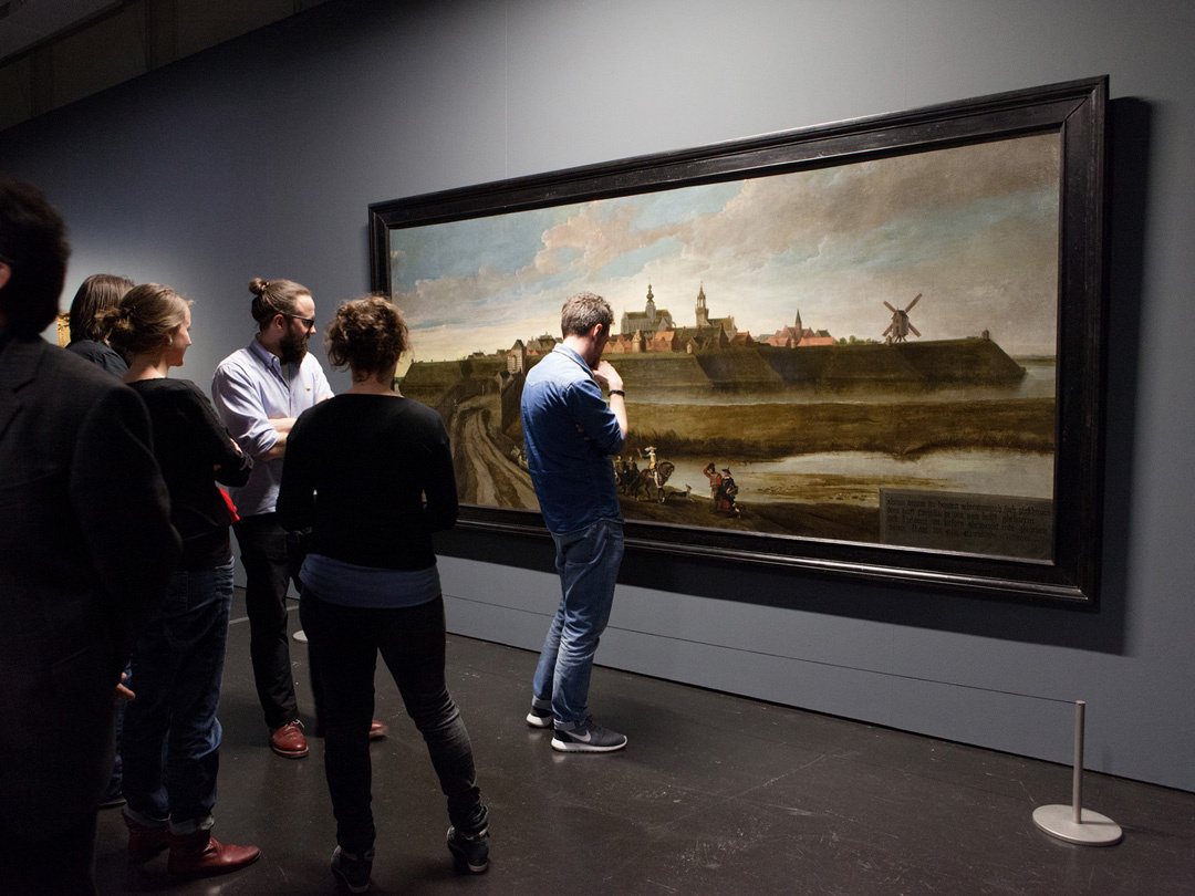 Persons in the exhibition »Mapping Spaces« in front of a painting
