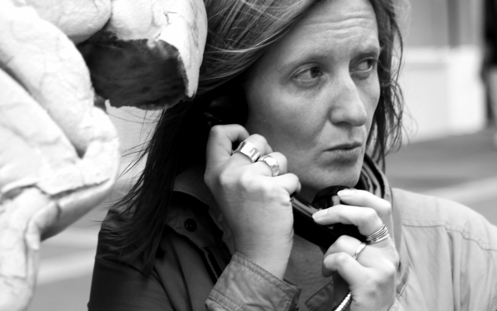 A black and white photo of a woman holding a corded phone