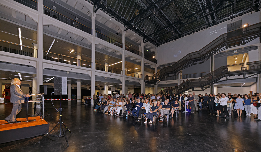 A man standing in front of a sitting crowd