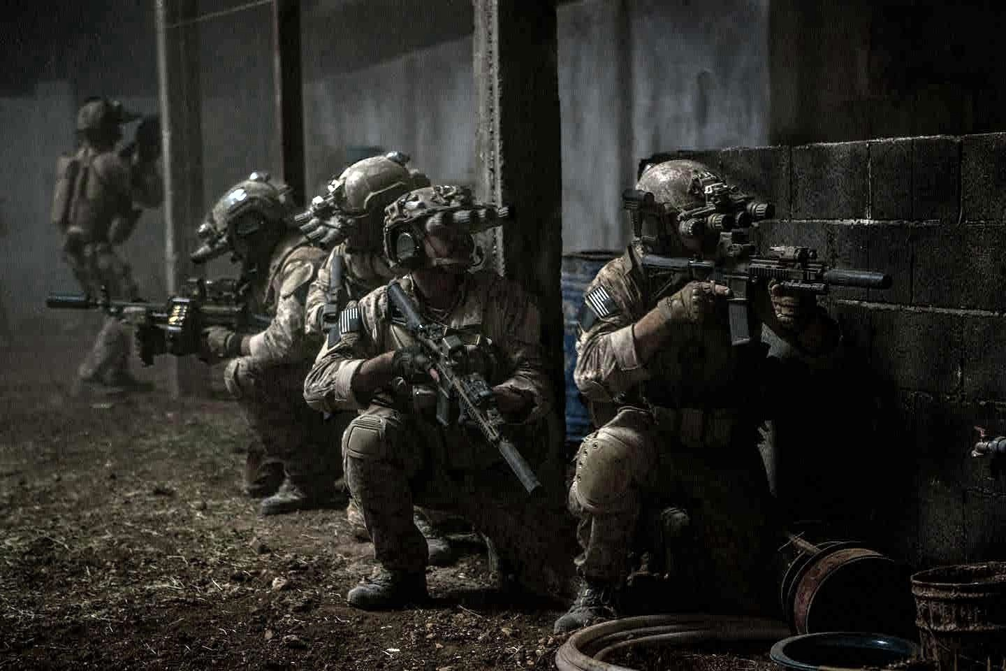 Armed people in front of a wall