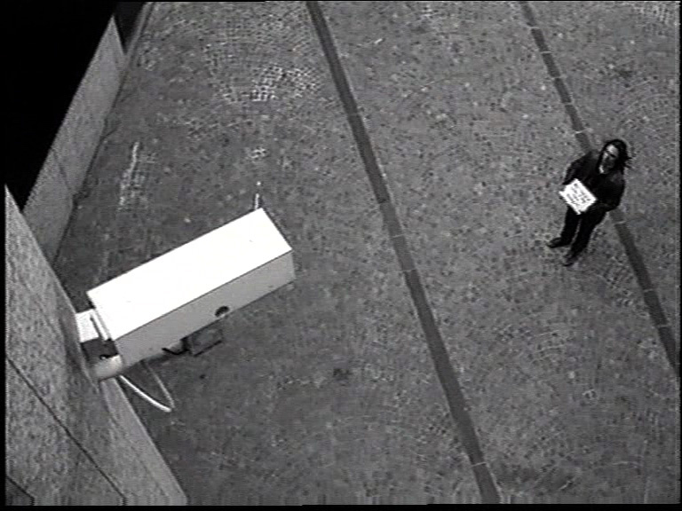 A man stands in front of a surveillance camera