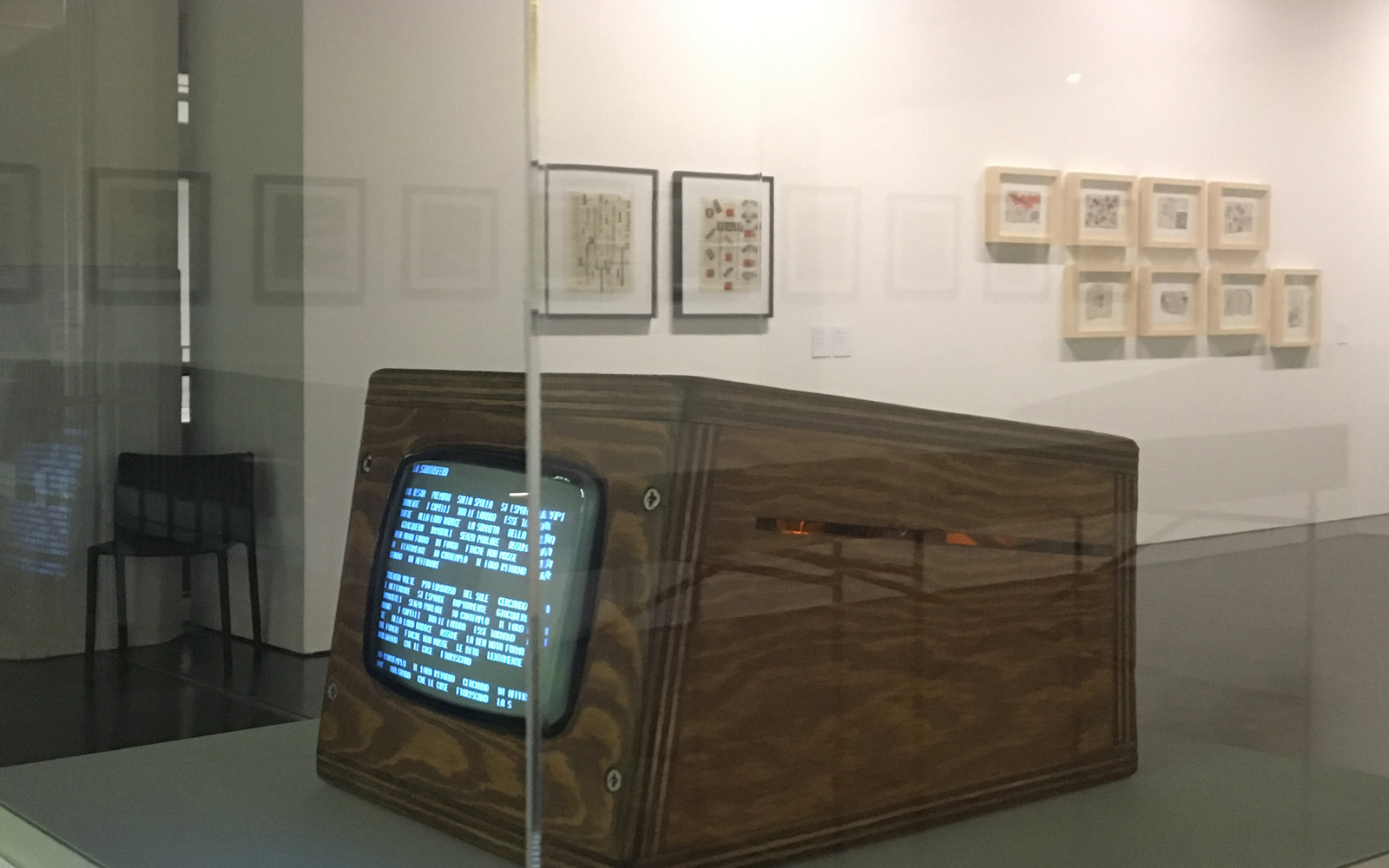 Photo of the reconstruction of the poem "Tape Mark I" by Nanni Balestrini: a small wooden box with a screen