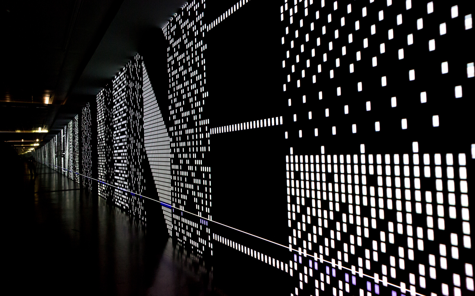 Eine schwarze Leinwand mit gepunkteten LED-Strukturen, die sich scheinbar bis Unendliche erstreckt. 