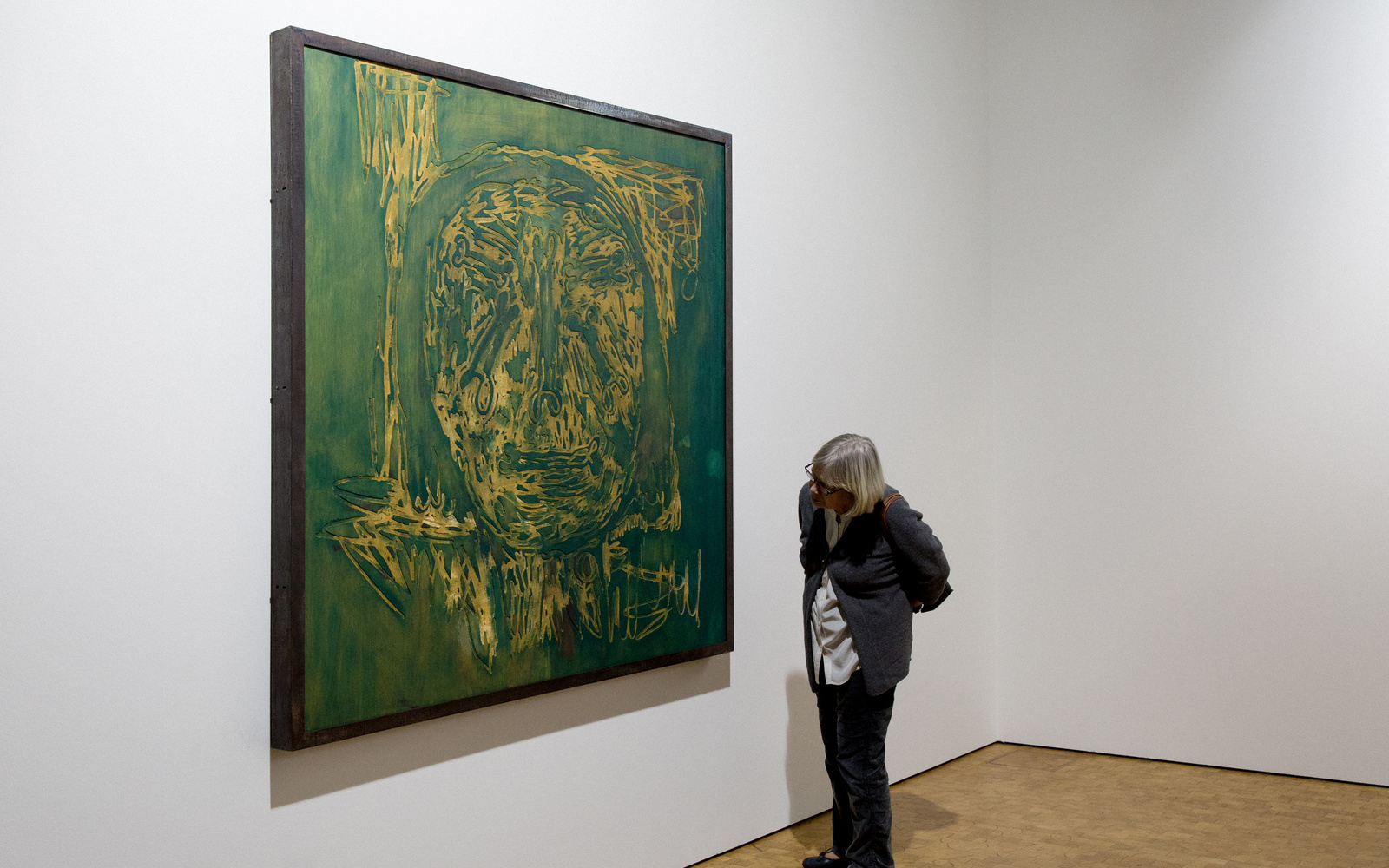 The picture shows a woman in front of a painting by Markus Lüperz