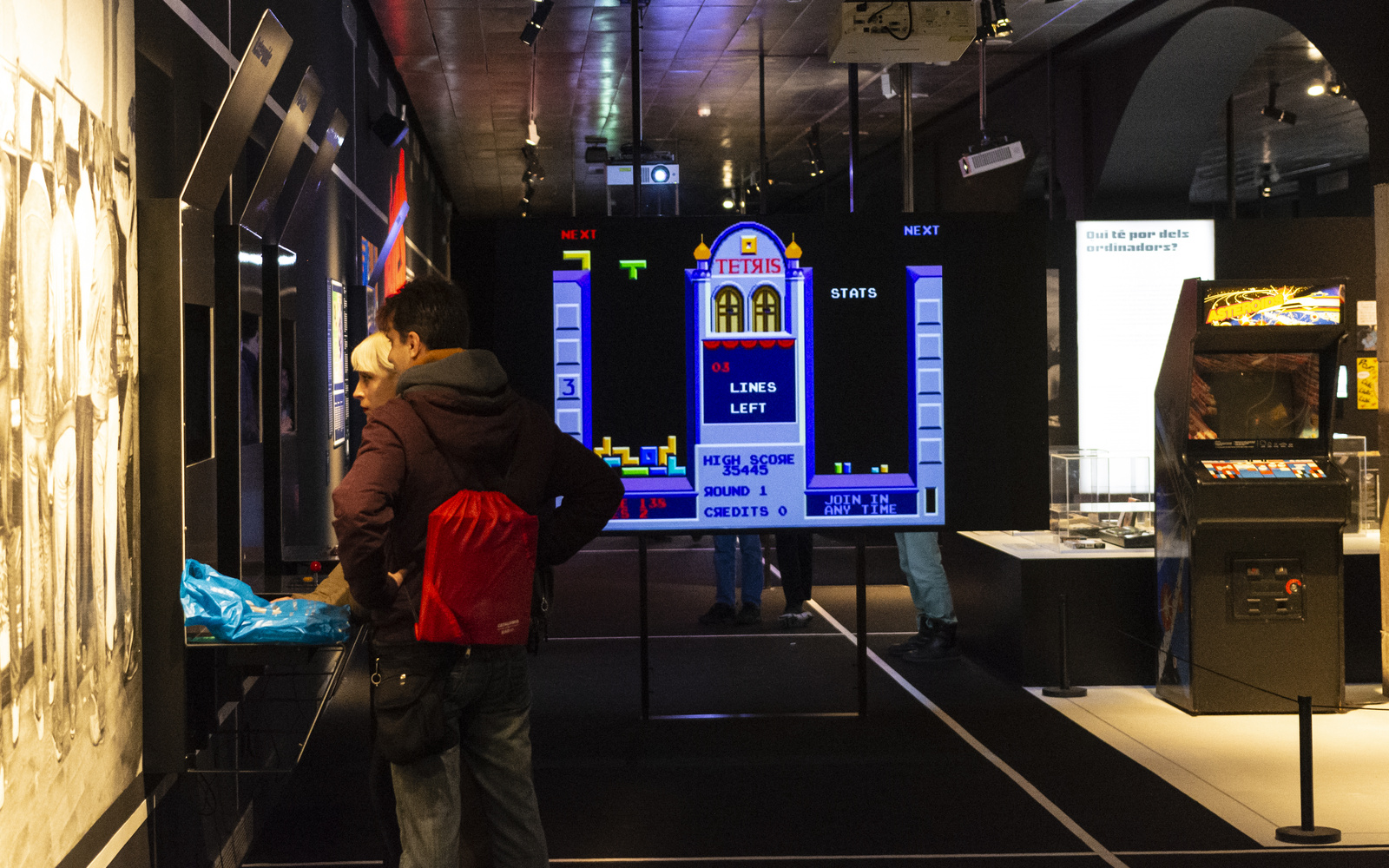 Two people stand in front of a screen in the exhibition room »zkm_gameplay«.
