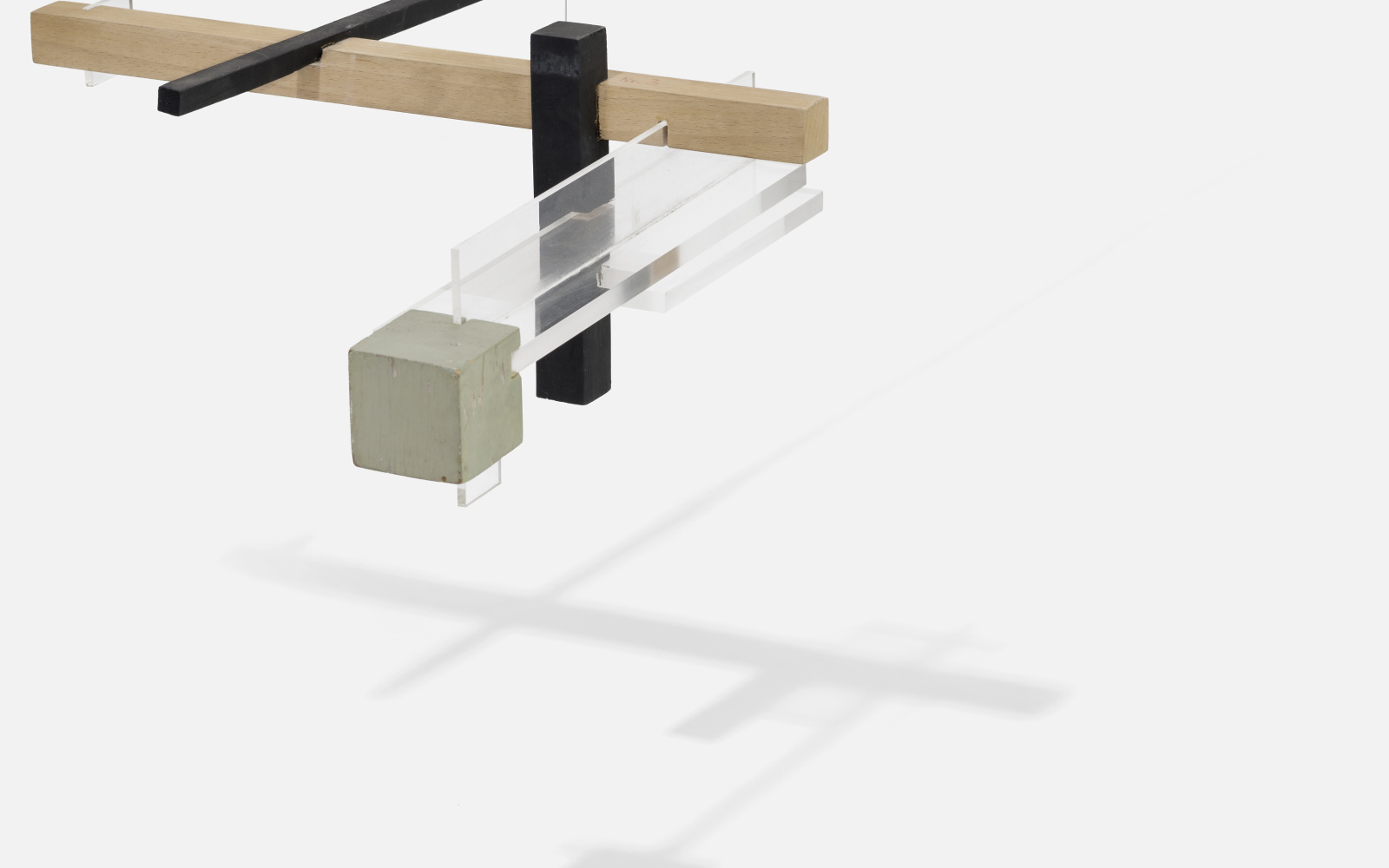 On a string hangs a structure of wood, plexiglass and metal, which is balanced and the protruding beams are horizontal.