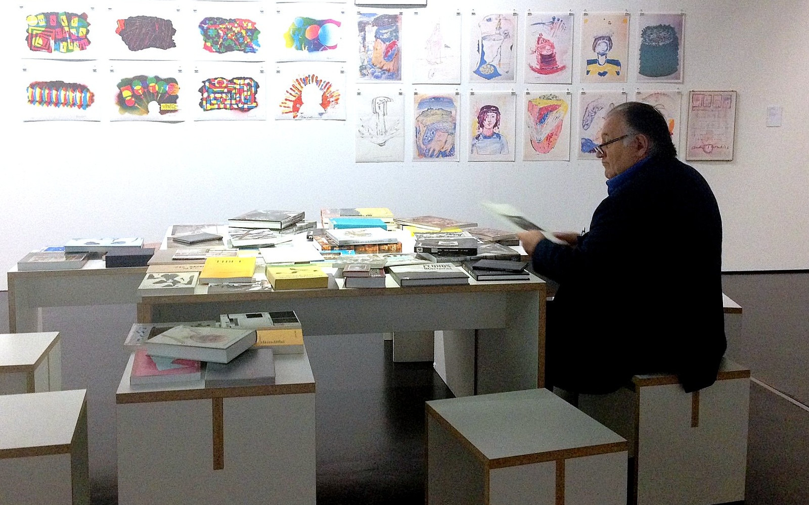 Peter Weibel sits at the ZKM at a table with books
