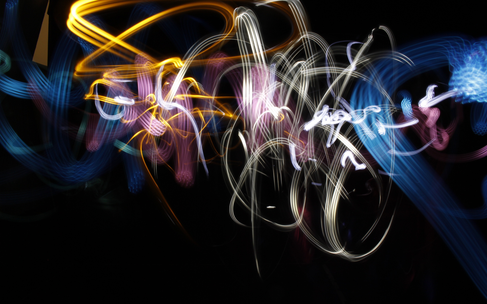Using a flash light and a camera with longterm exposure, a light graffiti has been created. In abstract forms there are whirling yellow, white and blue stripes across the black background.