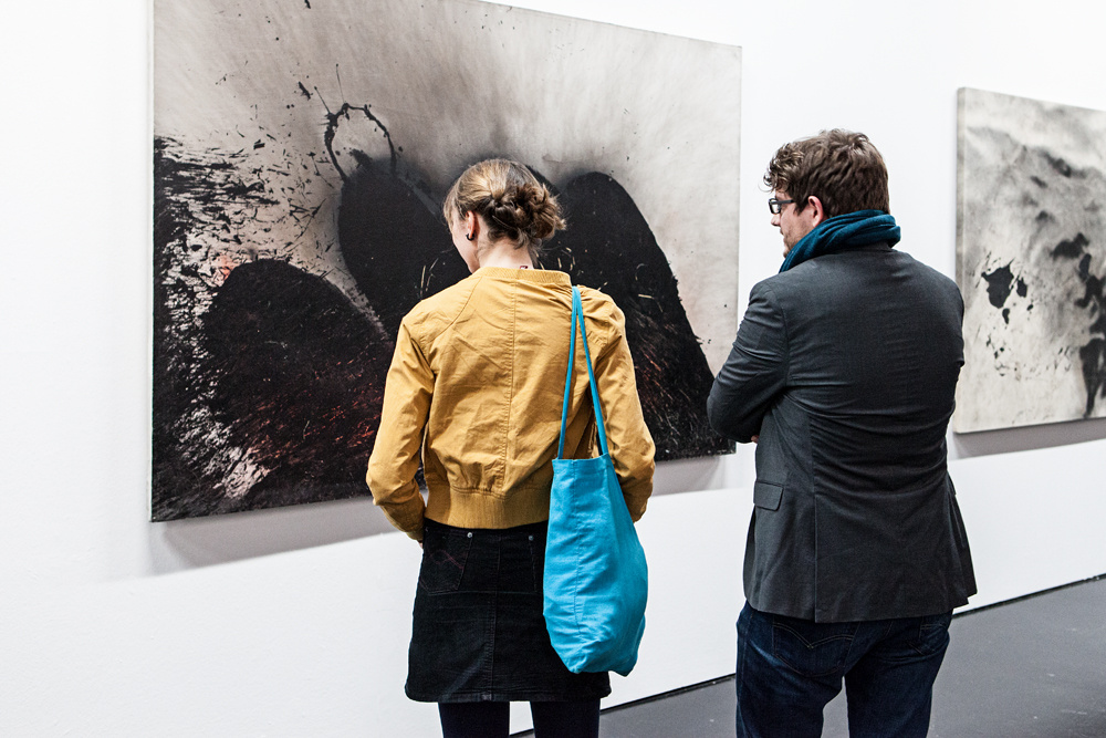 Two people standing in front of Otto Piene's images.