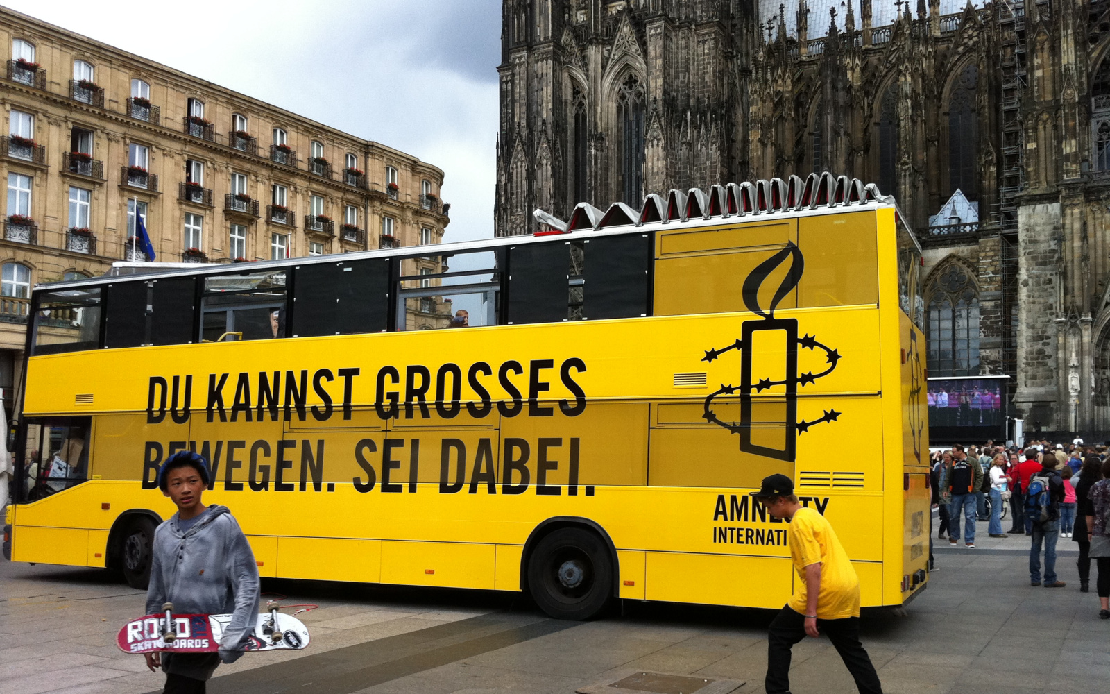 Gelber Doppeldeckerbus von Amnesty International