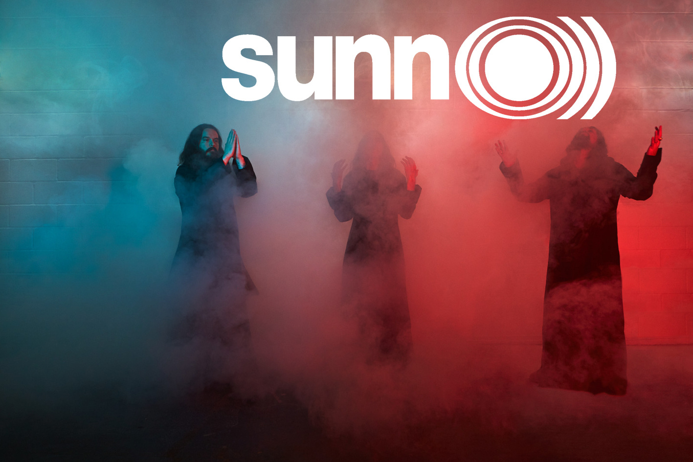 Die drei Musiker der Metalband »Sunn O)))« stehen im blau, weiß und roten Nebel.