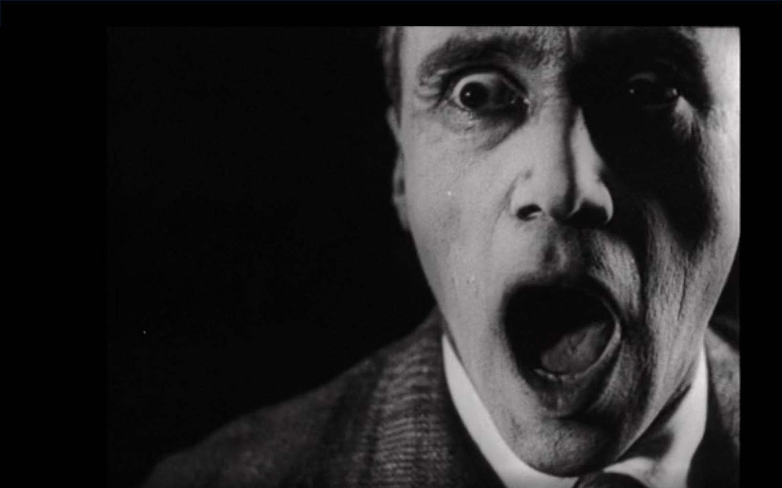 Bild aus dem Film »Alles dreht sich, Alles bewegt sich« von 1929. Abgebildet ist ein Mann mit aufgerissenem Mund in Schwarz-Weiß.