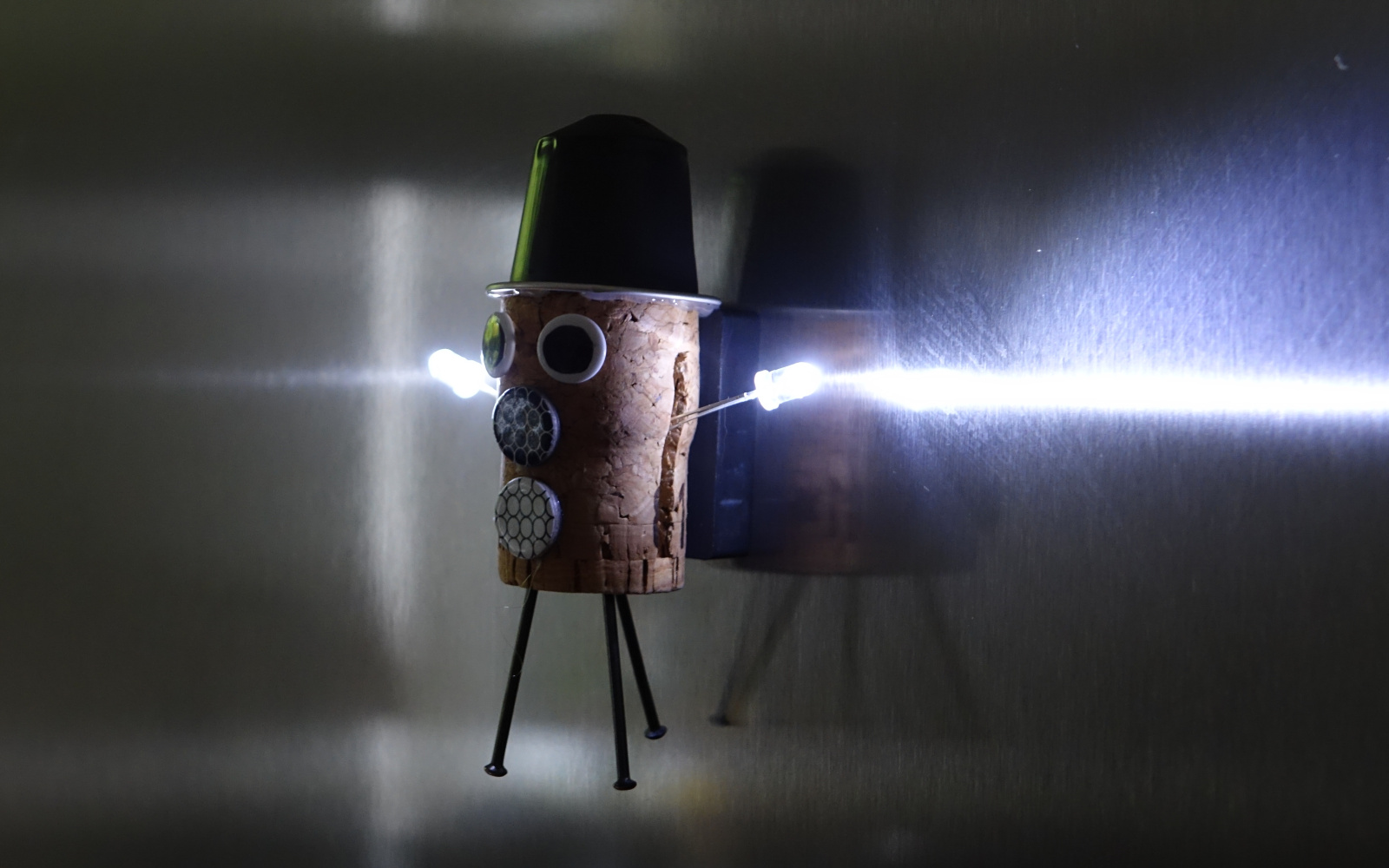 Fantasiefigur hängt mit LEDs am Kühlschrank