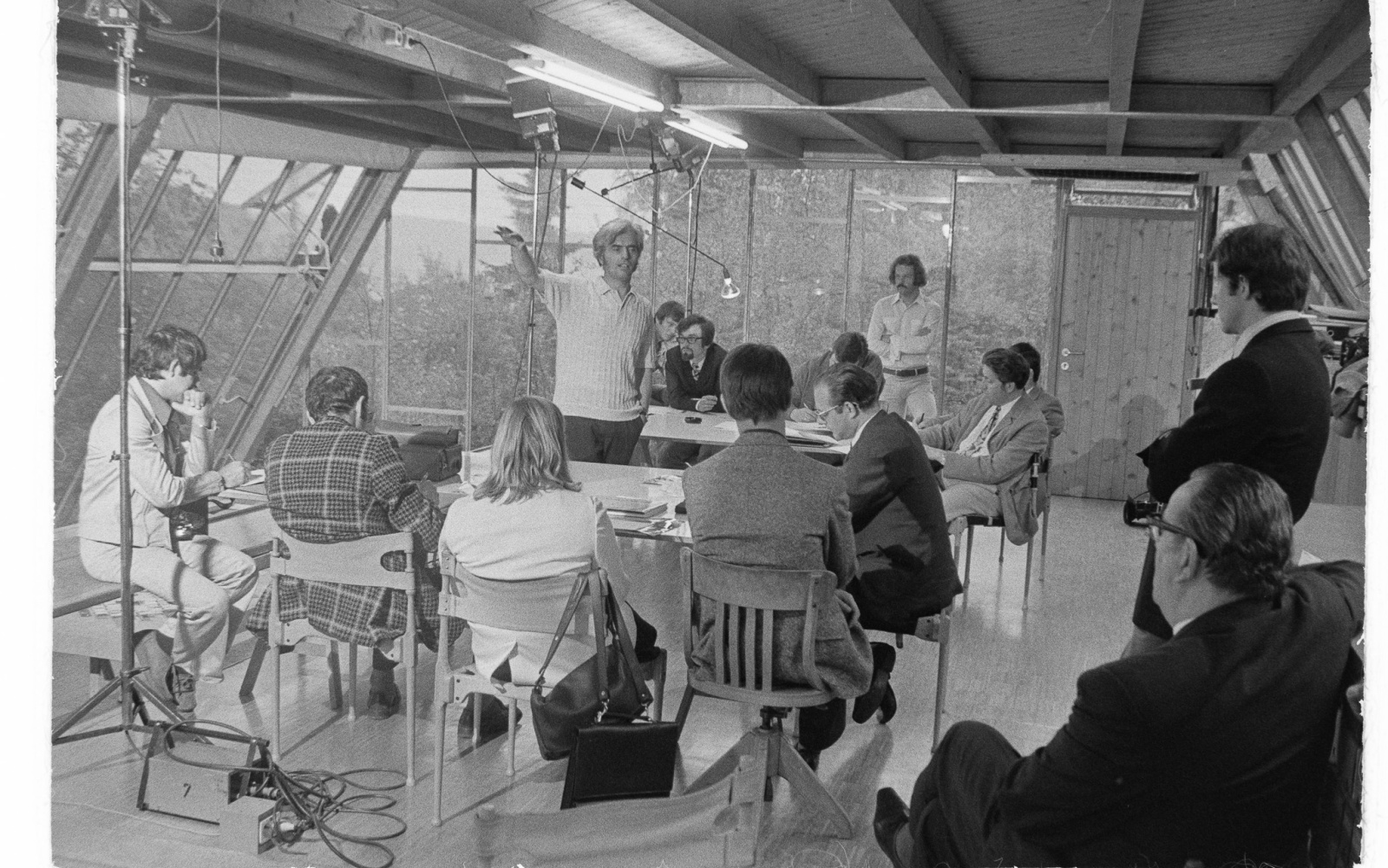 Eine alte schwarz-weiß Aufnahme des Architekten Frei Otto, der in einem Kreis von Zuhörern steht