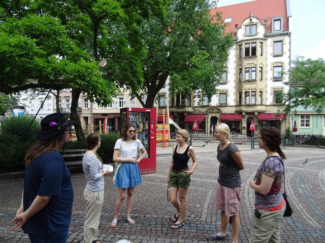 Das Foto zeigt sechs Personen im Halbkreis stehend während der Konsum-Global-Karlsruhe Führung.