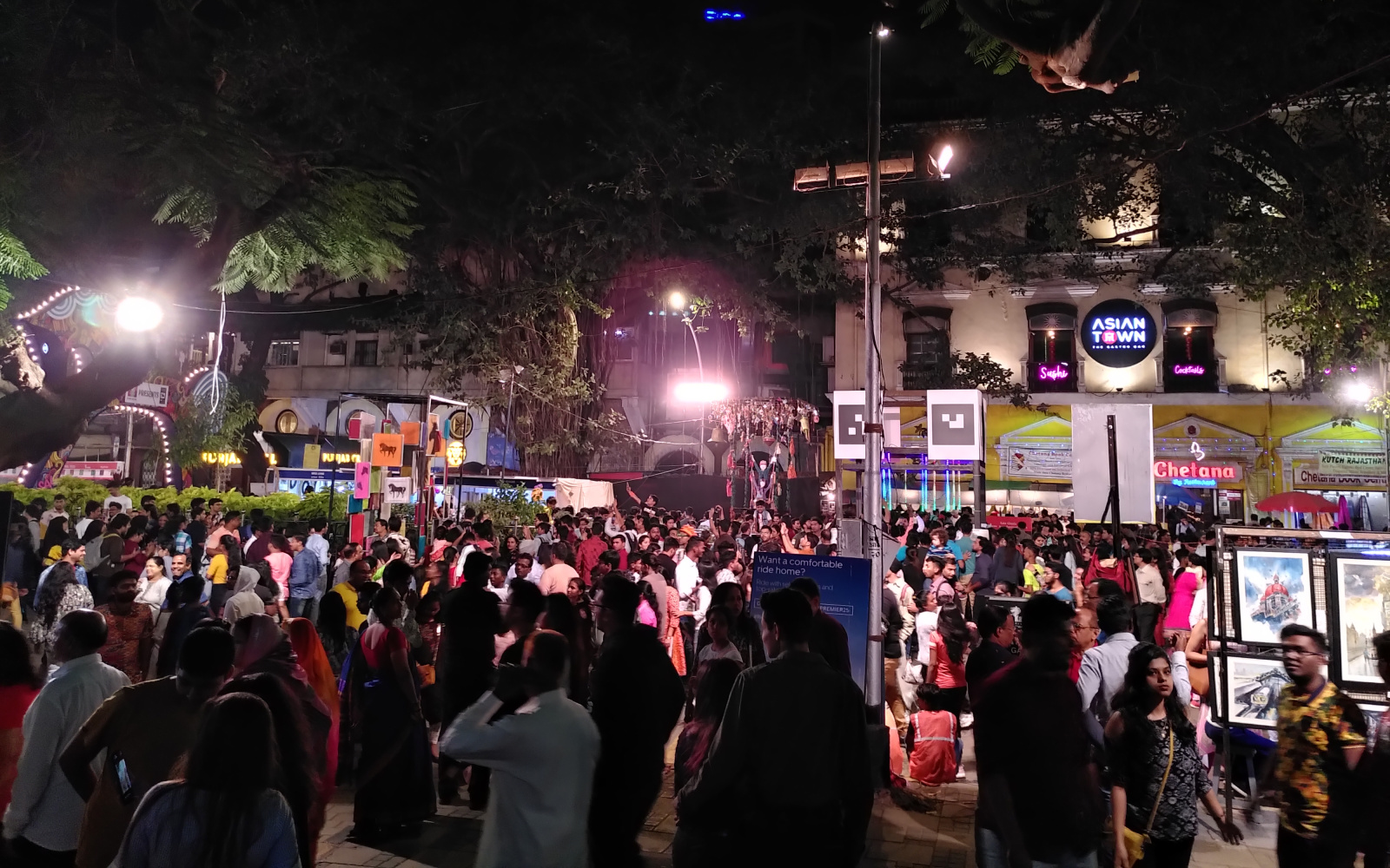 Viele Menschen auf einer Straße bei Nacht versammelt im Rahmen des Kala Ghoda Festivals in Mumbai. 