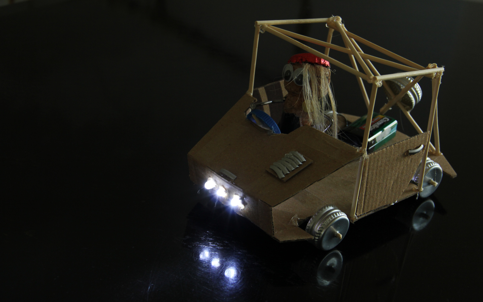 Eine "Maker"-Fantasiefigur ist in einem Auto sitzend zu sehen 