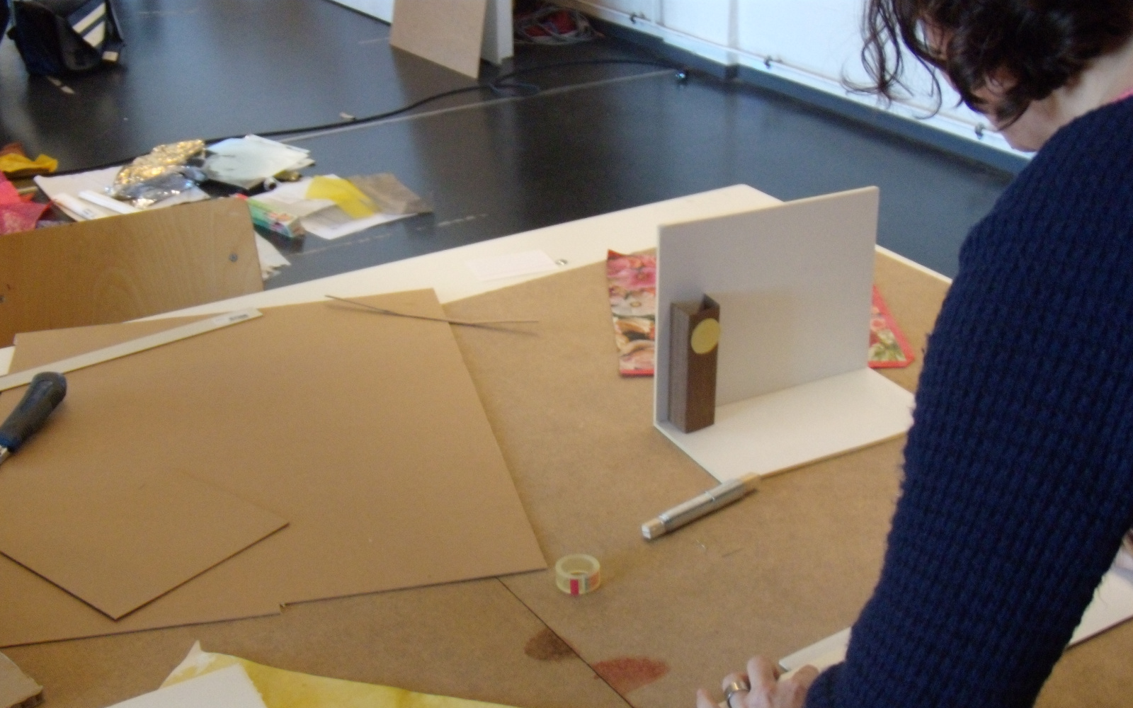 A woman is working on a miniature stage scenery