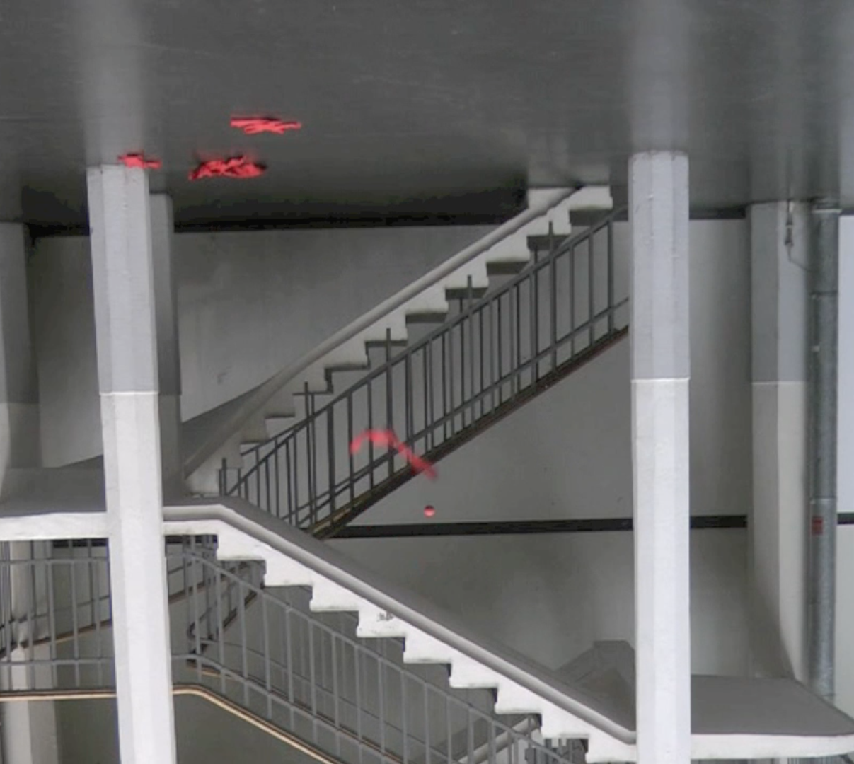 Ein Treppenhaus ist verkehrt herum zu sehen, ein roter Stoffstreifen und ein Ball scheinen nach oben zu fallen.