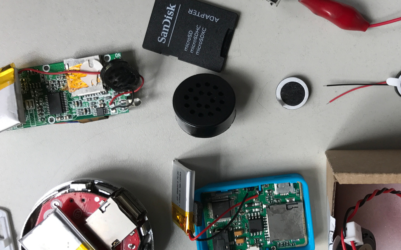 Technische Geräte und eine SD-Karte auf einer grauen Tischplatte