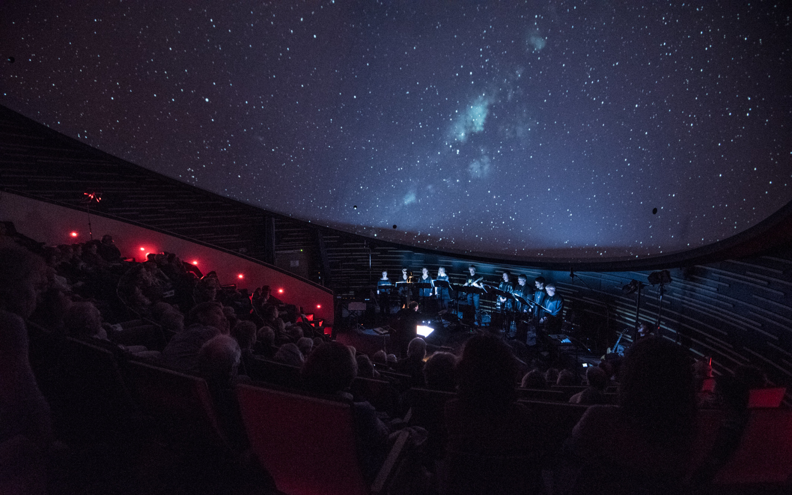 Das KlangForum auf der Bühne vor einem projizierten Sternenhimmel
