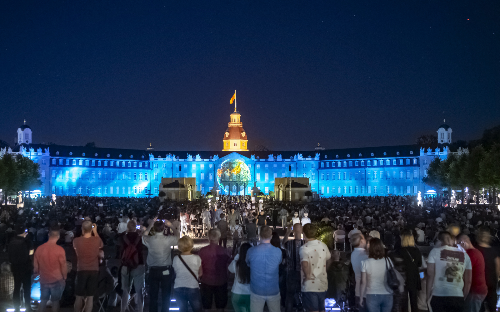 At the centre of the palace facade below the palace tower, the world globe lights up in a blue sea.