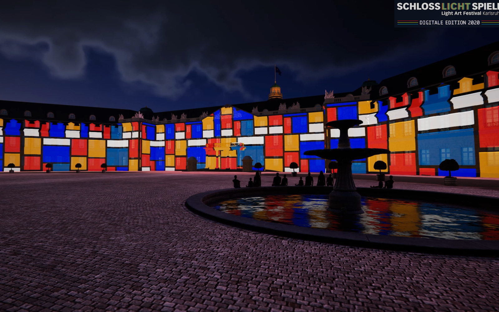 The Karlsruhe palace is digitally reconstructed. Many coloured squares are projected onto its surface. In the front right is a fountain with a few people sitting at its edge. It is an extremely realistic image