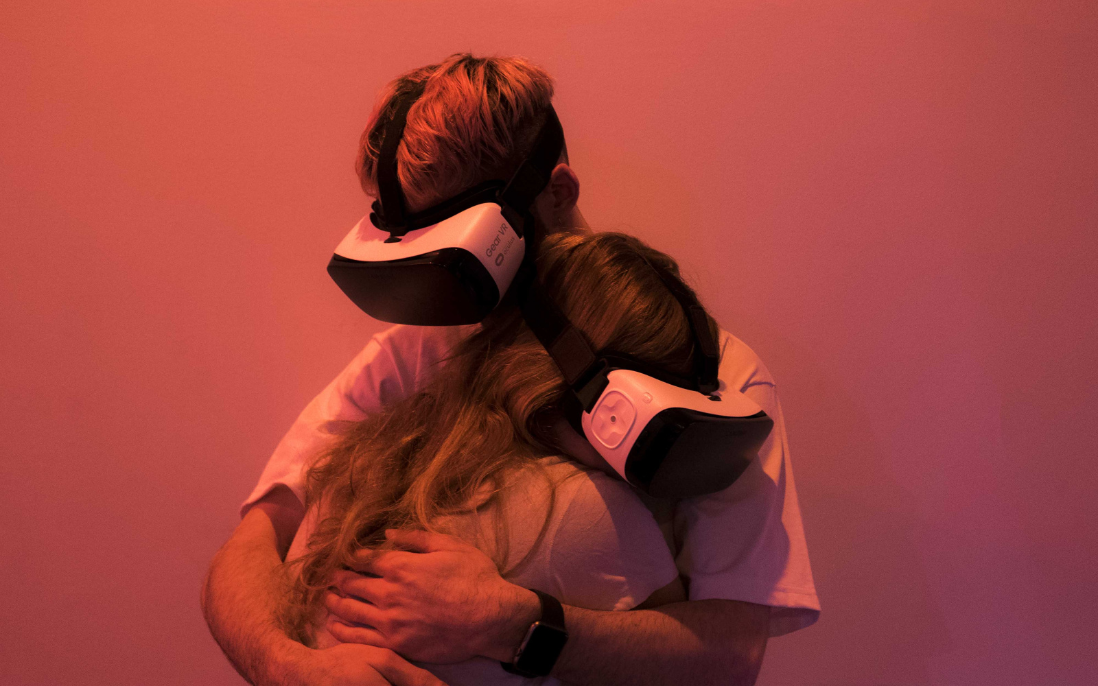 Two people with VR glasses hug each other 