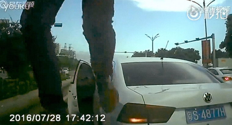 Bild einer Überwachungskamera: Zwei Beine, dahinter ein Taxi
