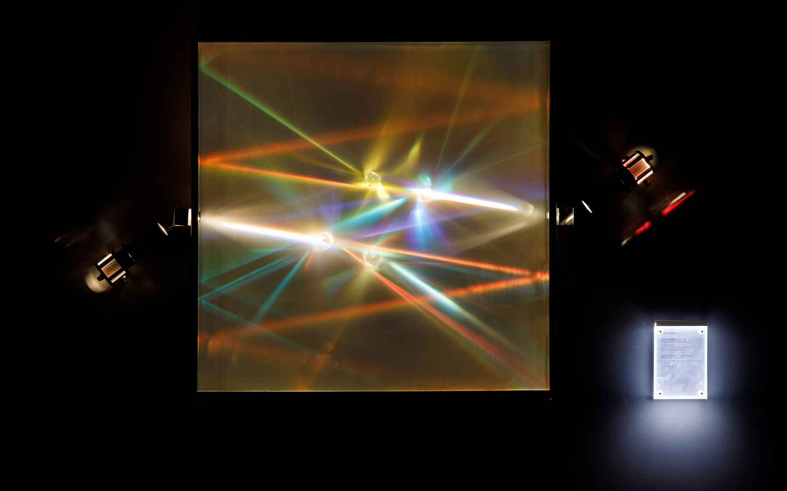 Light from two lamps is refracted into prisms and produce all the colours of the rainbow at different angles.