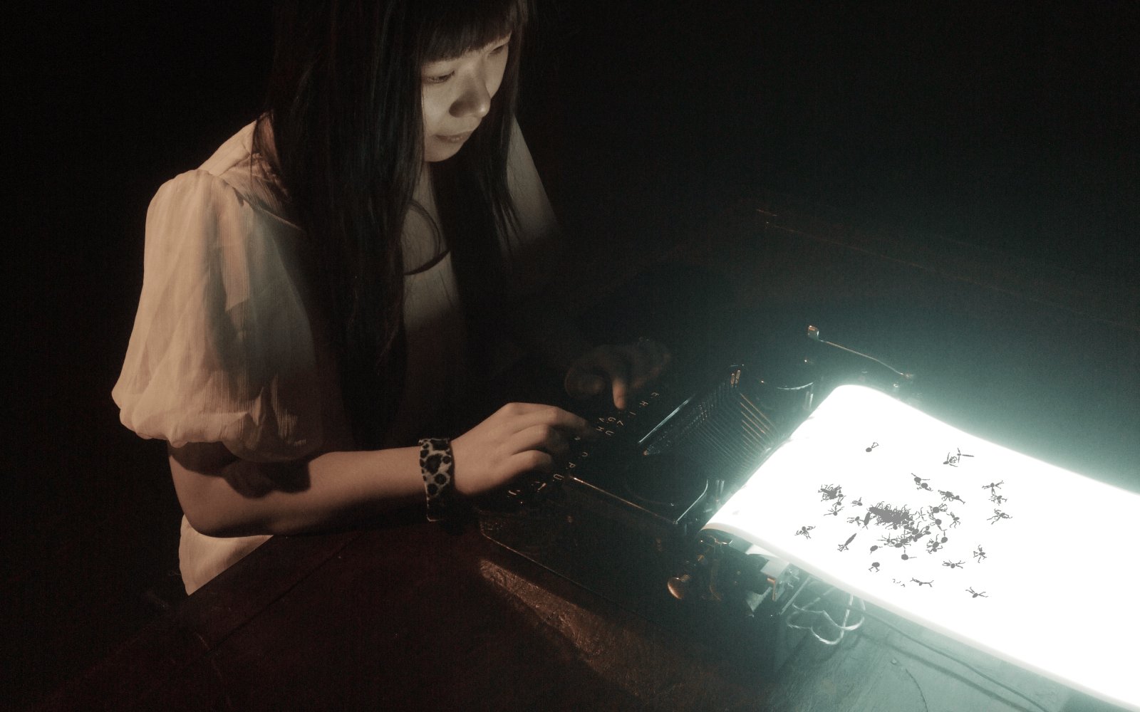A woman is typing on a glowing typewriter
