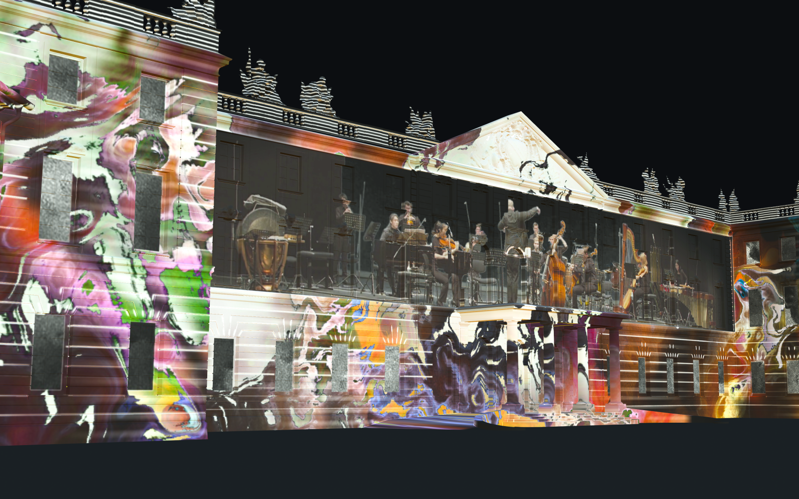 Auf der Karlsruher Schlossfassade ist ein Projection Mapping zu sehen, das in der Nacht leuchtet. Das Mapping zeigt bunte Farbwirbel, in deren Mitte ein Orchester spielt.